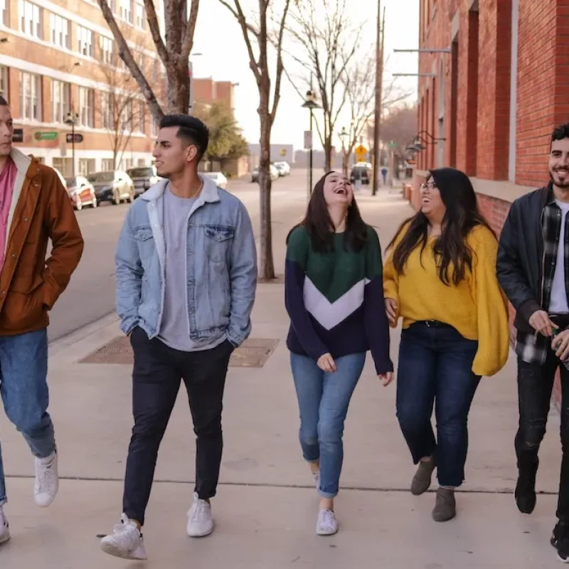 group of students walking together along a sidewalk